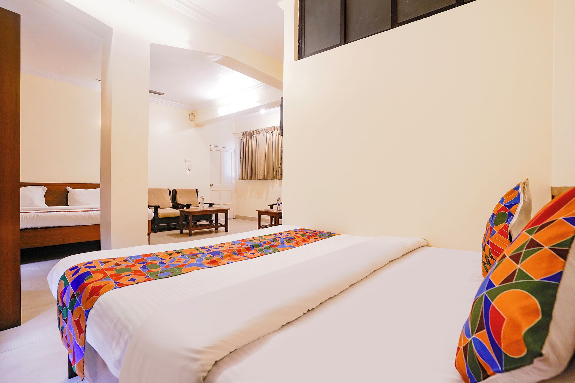 Una habitación de hotel con una cama, un escritorio y una silla.