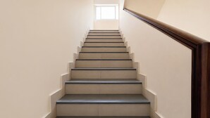 A staircase with a wooden handrail and a light-colored wall.