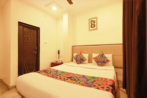 A hotel room with a bed, a bedside table, a telephone, and a wall-mounted picture. - Fabhotel Ssr (Khammam)