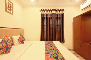 A hotel room with a bed, a wardrobe, and a curtain. - FabHotel Ssr (Khammam)