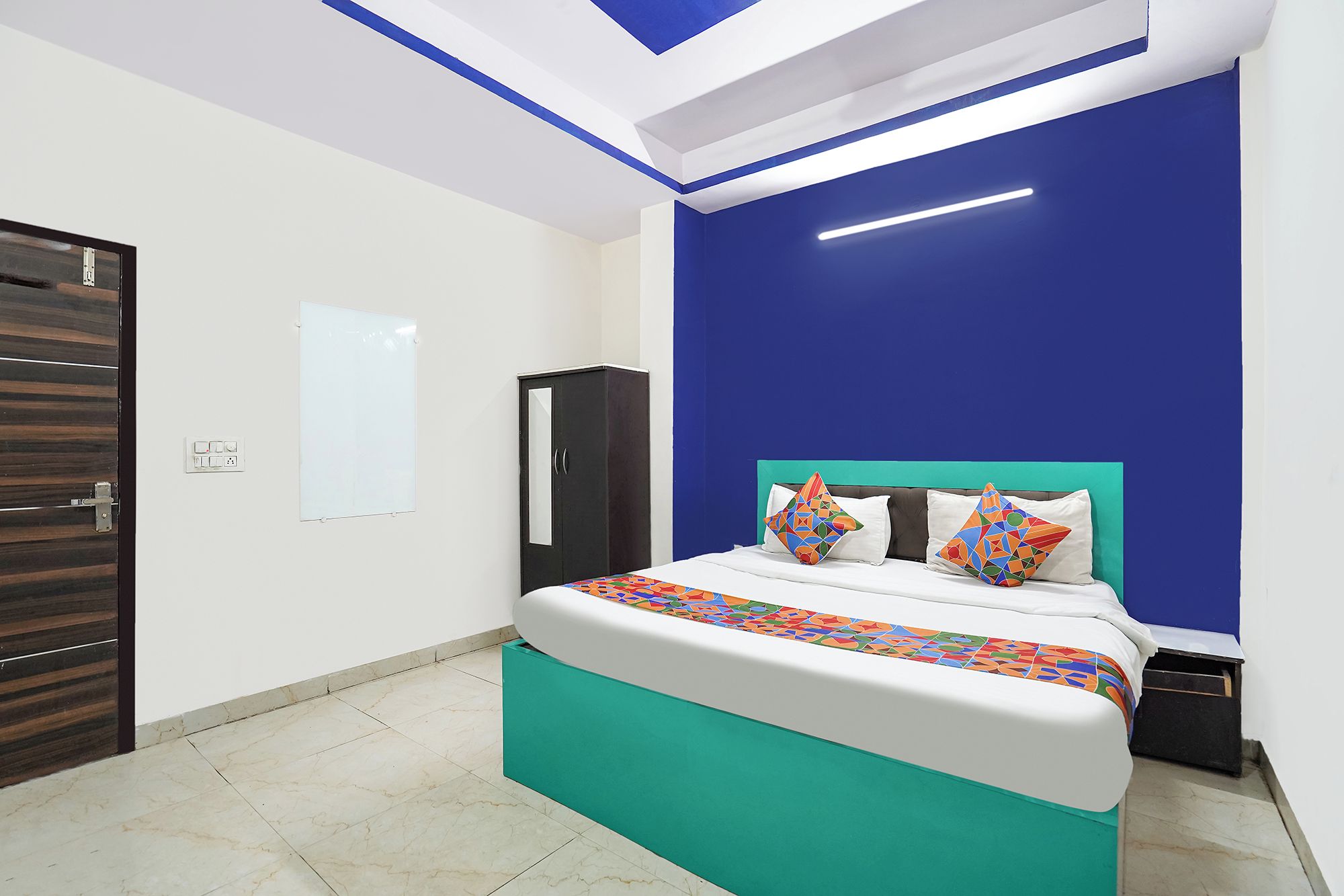 A bedroom with a bed, a wardrobe, and a whiteboard on the wall.