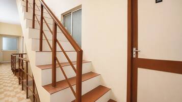 A staircase with wooden handrails and a door marked '307' on the right.