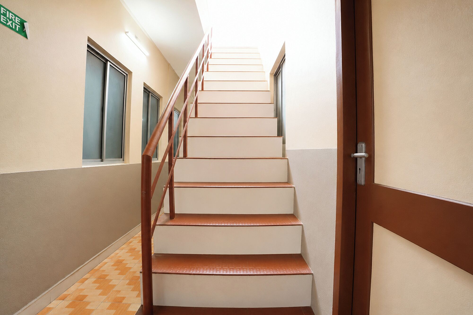 A staircase with a handrail, leading to a door with a keyhole.