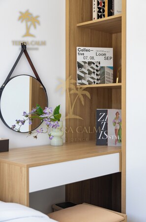 Un dormitori modern amb un panell de fusta al cap, una taula de nit amb un mirall, una petita planta en test i un llibre titulat 'ZARA CALM STYLE'.
