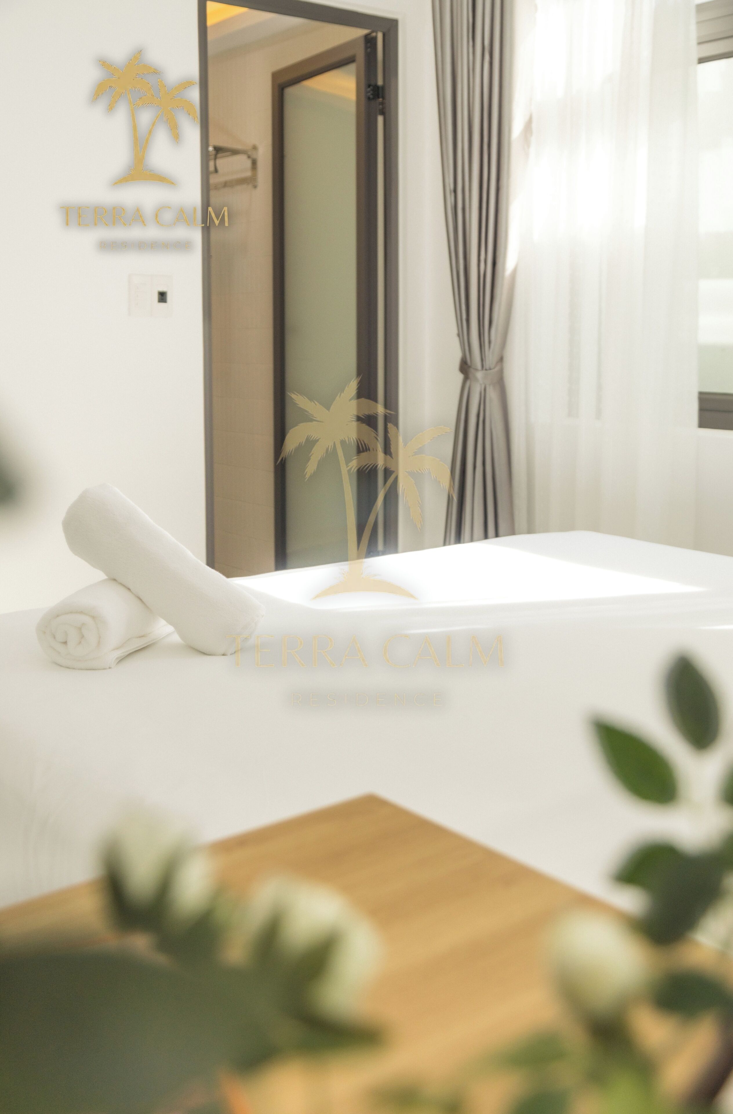 Ein Hotelzimmer mit Bett, Handtuch, Holztisch und Spiegel.