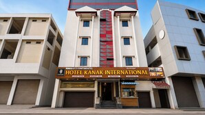 Um hotel com fachada moderna, exibindo uma placa chamativa do Hotel Kanak International.