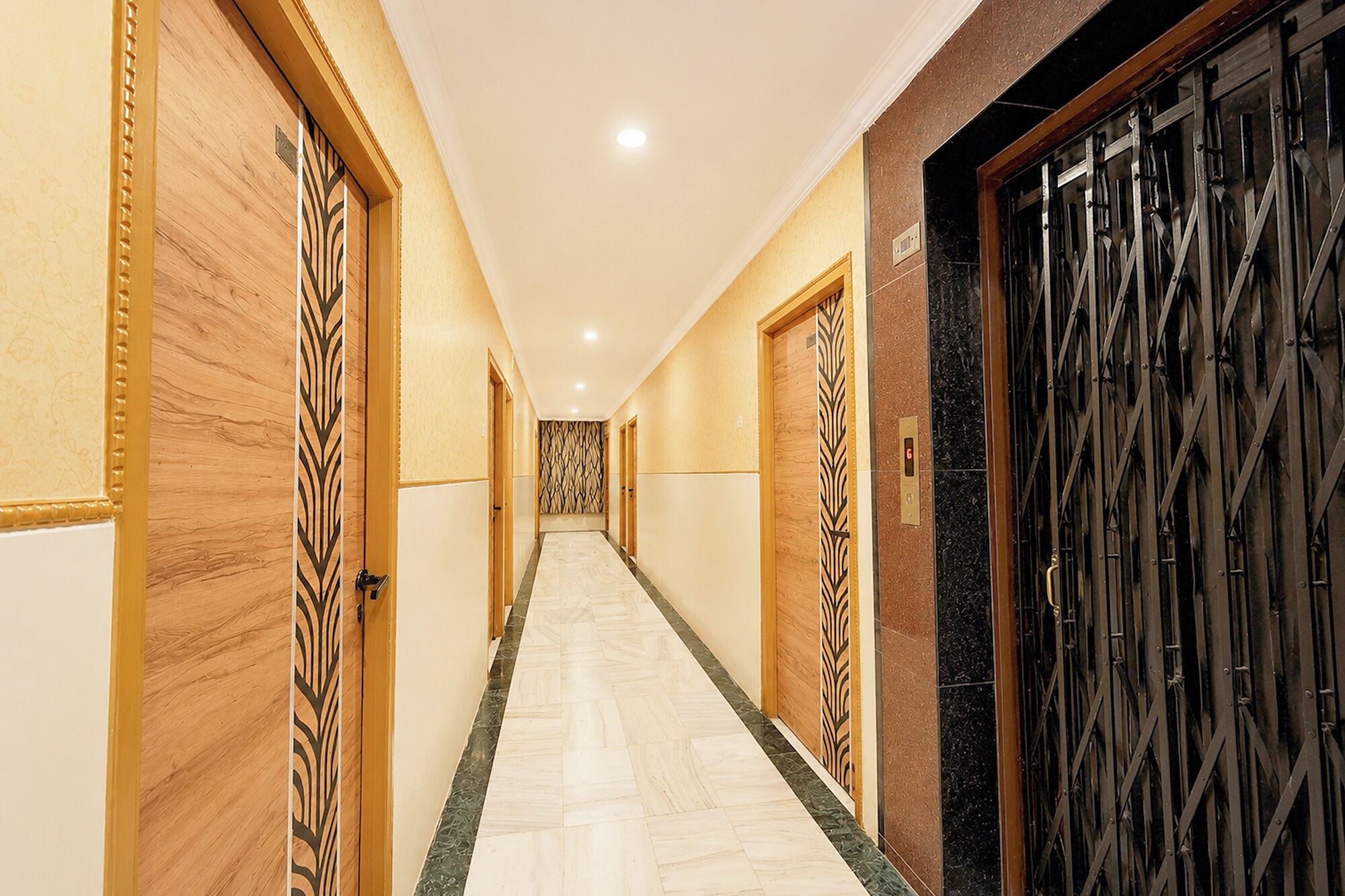 Un pasillo con puertas de madera y una reja metálica, que da a una habitación.