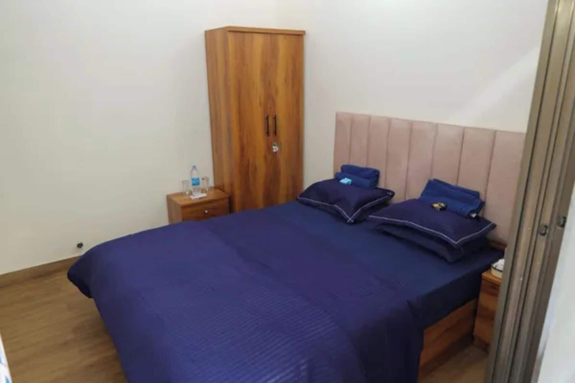 Ein Schlafzimmer mit Bett, Kleiderschrank und Nachttisch.