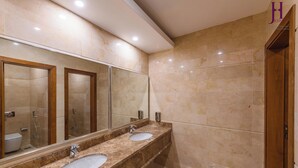 A bathroom with two sinks, a large mirror, and a shower area. - Joury Al Hada Hotel (Makkah)