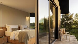 A bedroom with a large bed, a nightstand, and a view of a deck with outdoor furniture. - Architect Hideaway Between Heath & the North Sea (Brovst)