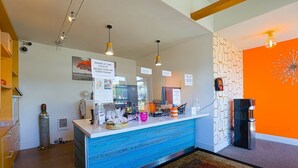 A reception desk with a blue patterned counter, overhead lighting, and informational signs.