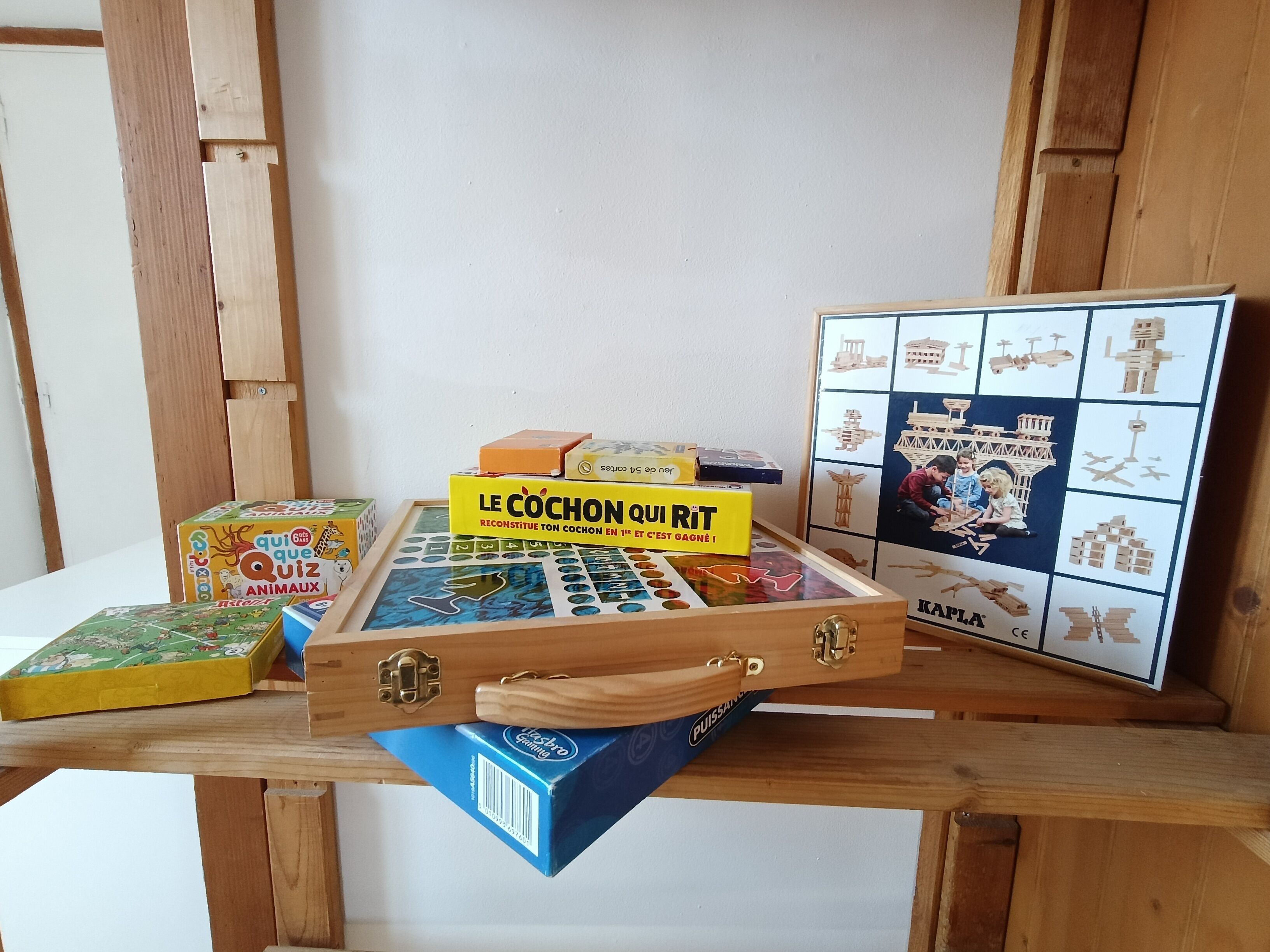Una mesa de madera con diversos juegos de mesa y rompecabezas, incluyendo un rompecabezas con tema de tren.