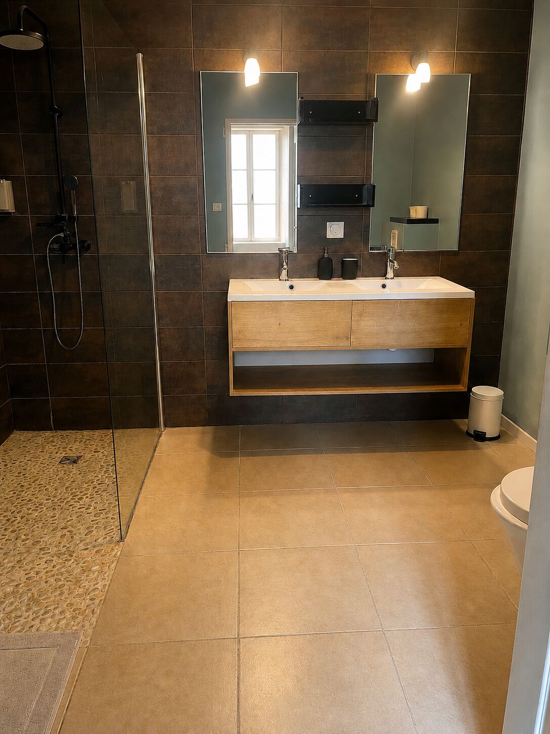 A modern bathroom with a double sink vanity, a shower area, and a large mirror.