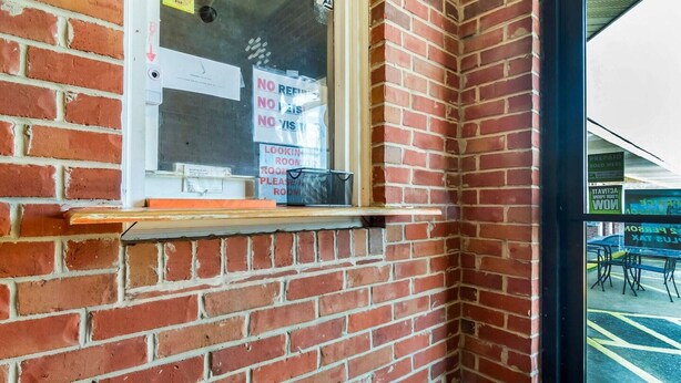 Eine Ziegelwand mit Fenster und Ablagefläche.