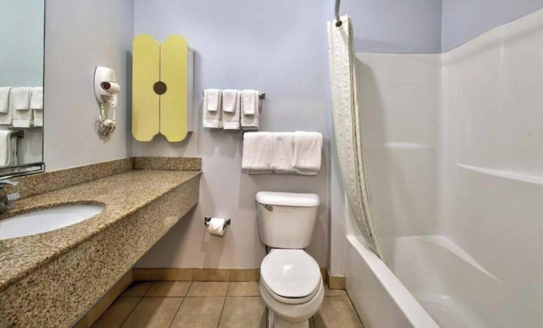 A bathroom with a sink, toilet, and bathtub.