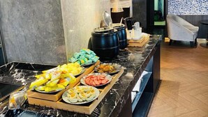 A buffet setup with various food items, a marble countertop, and a modern interior design. - Crystal Orange Hotel Hangzhou Qianjiang New City Jinjiang (Hangzhou)