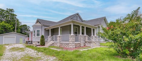 A two-story house with a covered porch, a garage, and a small front yard.