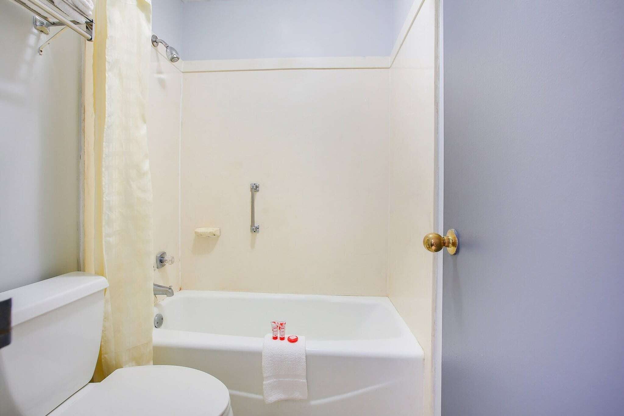 A bathroom with a toilet, a bathtub, and a shower curtain.