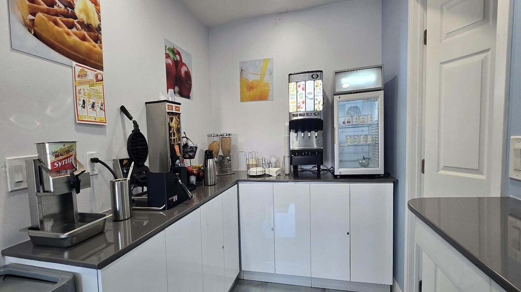 Una cocina con cafetera, nevera y plancha para gofres.