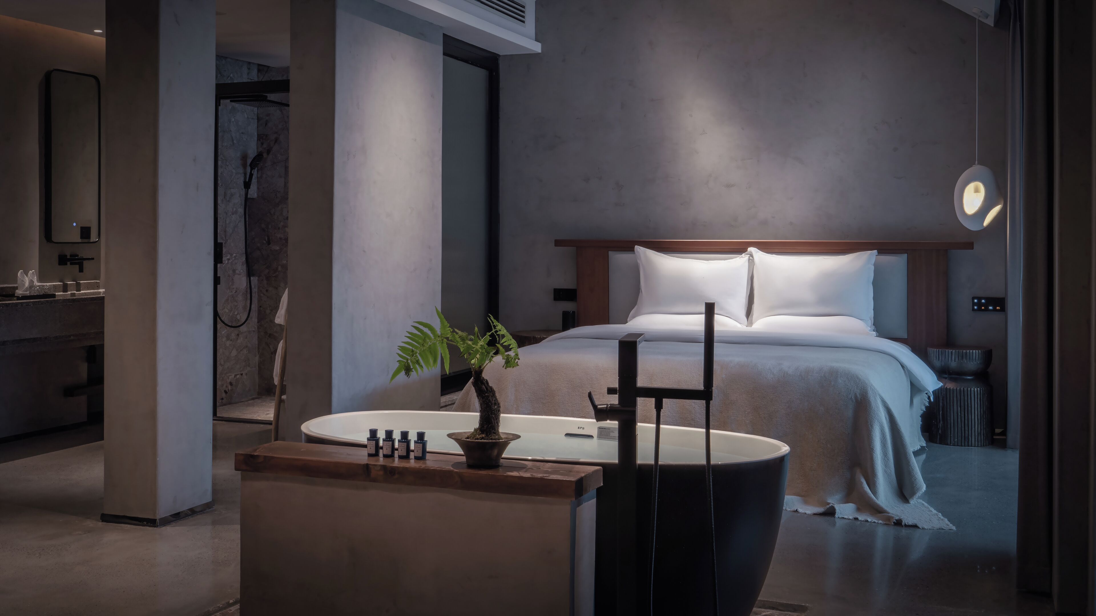 Une chambre à coucher moderne avec un lit, une table de chevet et une petite plante.