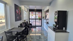 An interior with a dining area, a coffee machine, and a view of the street outside. - King Bed|Walkin|Victorville (Victorville CA)
