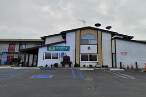 Ein Gebäude mit einem Schild, auf dem 'Quality Inn' steht.