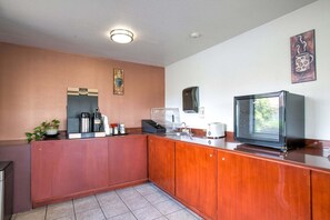 Una cocina compacta con cafetera, tostadora y microondas en la encimera.