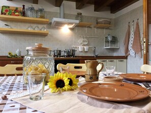 Una cocina con estantes de madera, una estufa y utensilios de cocina.
