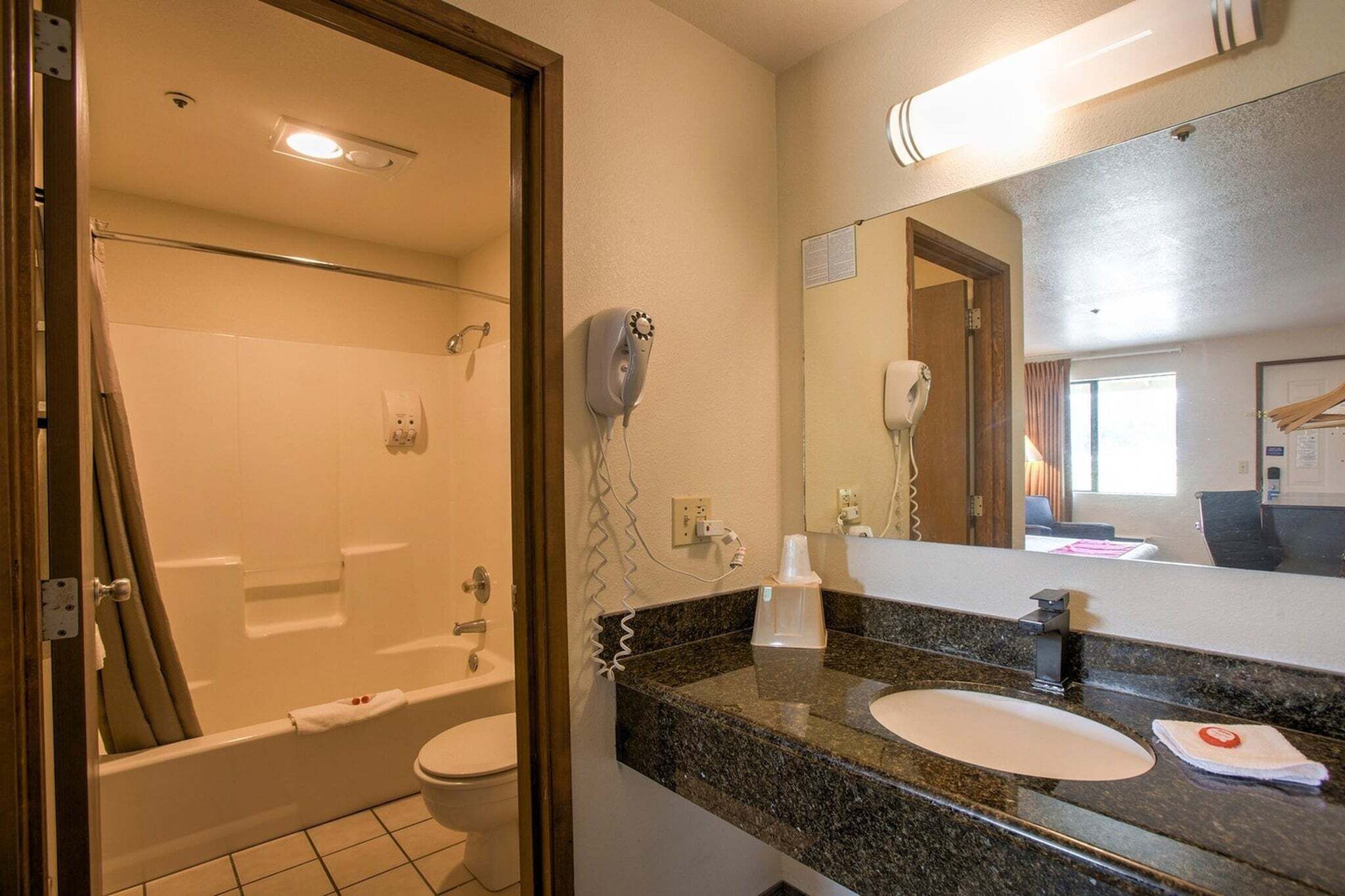 Une salle de bain équipée d’une douche, de toilettes, d’un lavabo et d’un miroir.