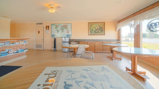 A library with bookshelves, a globe, a map, and a table with chairs. - Weslaco TX|King Bed Smoking (Weslaco TX)
