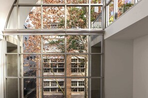 A multi-story building with large windows, brick walls, and visible balconies. - Manhattan Tri-Level Warehouse Style Apartment (Surry Hills)