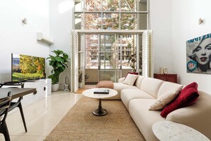 Una sala de estar moderna con un sofá, una mesa de centro y un televisor.