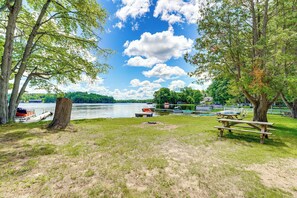 Un parque junto al lago con mesas de picnic, un muelle y botes.