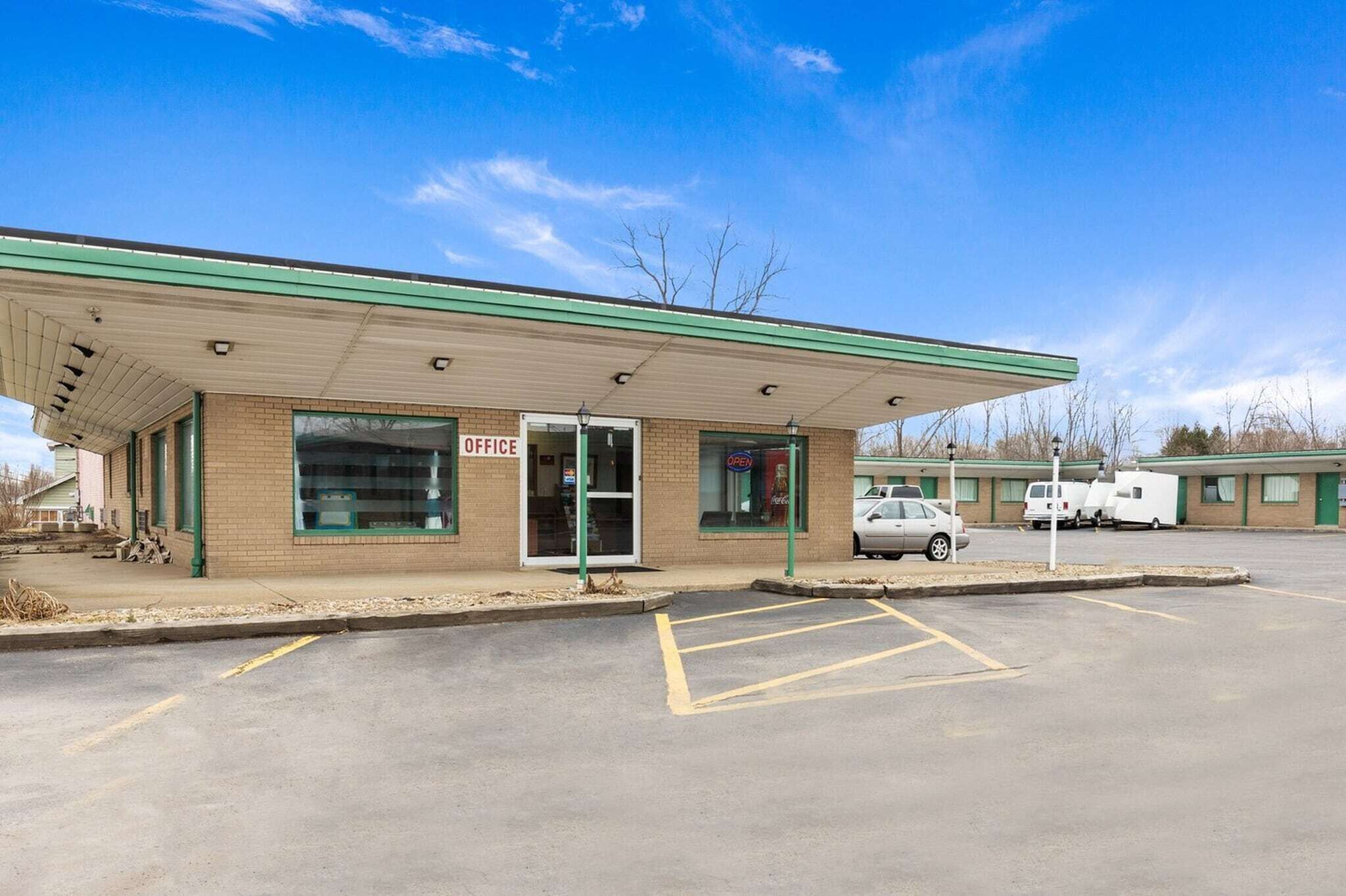 A building with a 'SERVICE' sign, a covered parking area, and a visible entrance.