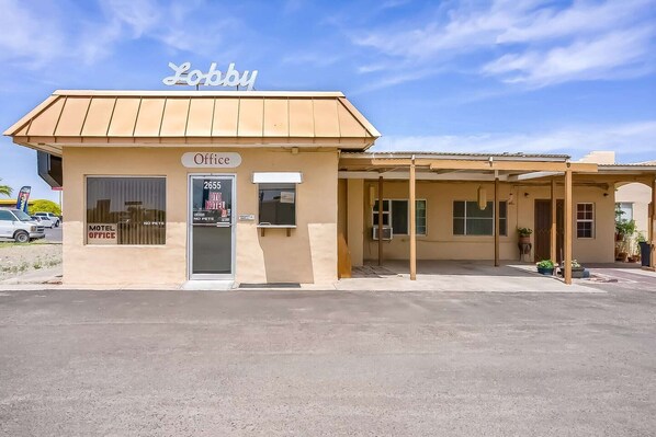 Un bureau de motel avec une enseigne indiquant « Réception » et le numéro « 2655 » sur la porte.
