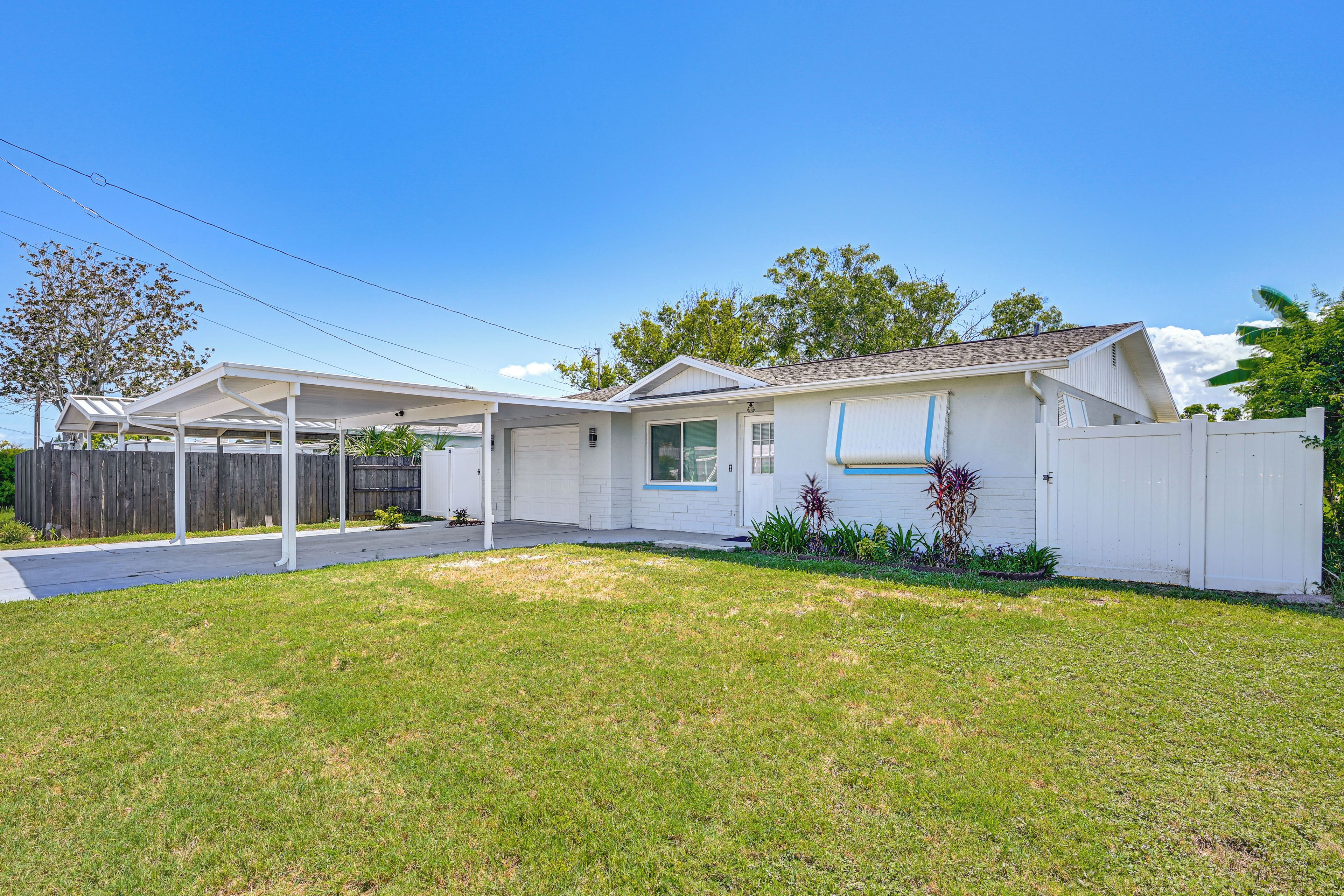 A single-story house with a covered porch, a garage, and a fenced yard.
