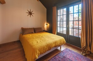 Ein Schlafzimmer mit einem Bett, einer Sterndekoration, einer Lampe, einem Fenster mit Vorhängen und einem gemusterten Teppich.