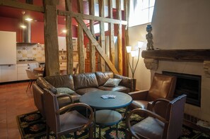 Ein gemütliches Wohnzimmer mit Ledersofa, einem runden Couchtisch und einem Kamin.