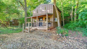 Una baita di legno con un portico, immersa tra gli alberi.