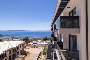 En moderne bygning med balkon med udsigt over kystlandskabet.