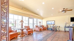 A lobby with seating, a reception desk, and a ceiling fan.