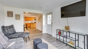 A modern living room with a sectional sofa, a glass console table, and a flat-screen TV. - Explore Seattle & Lake Washington! Mtn-View Apt (Renton)