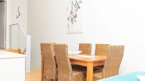 Un coin repas avec une table en bois et des chaises en osier.