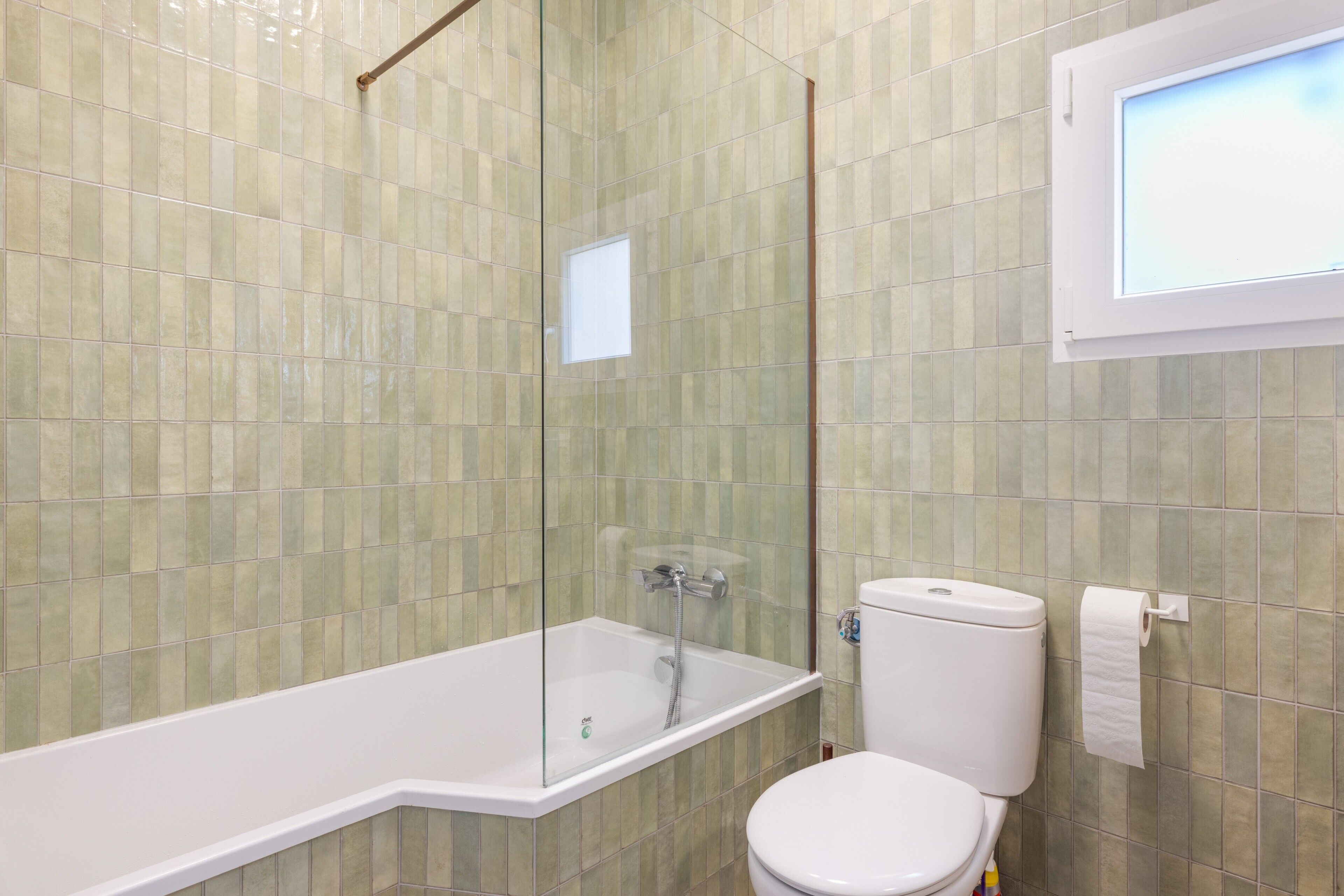 Ein Badezimmer mit einer Duschkabine, einer weißen Toilette und einer weißen Badewanne.