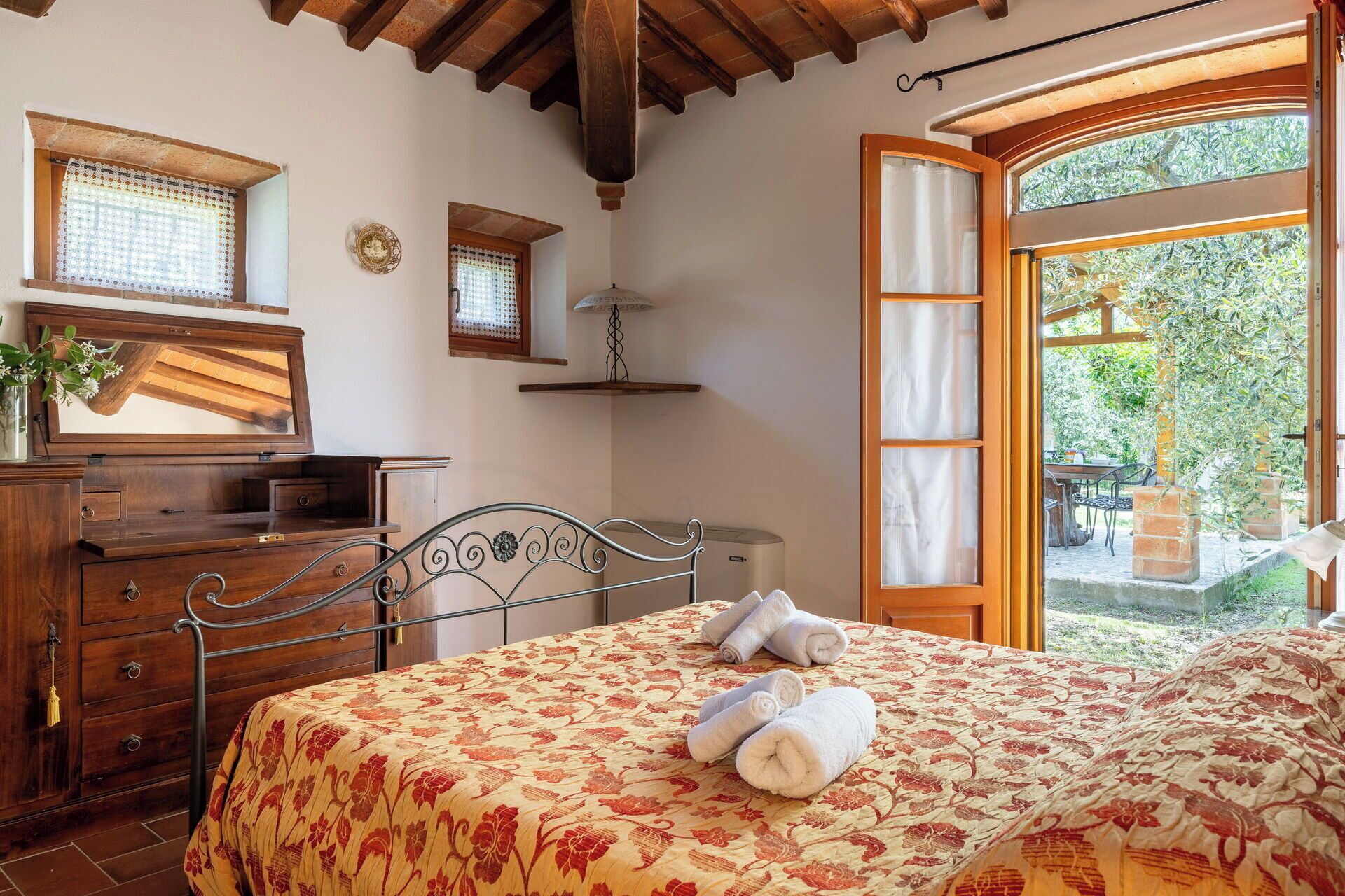Un dormitorio con cama, cómoda de madera y ventana con vistas al exterior.
