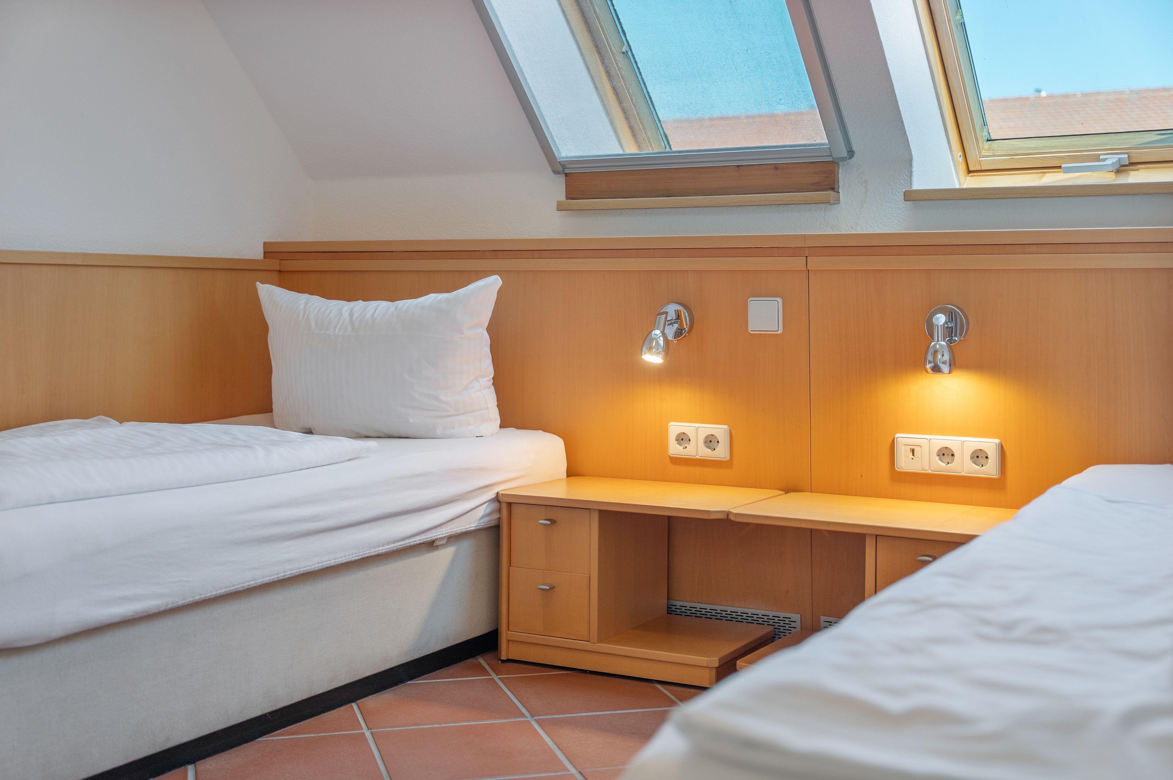 Un dormitorio con cama, mesita de noche y estante empotrado.