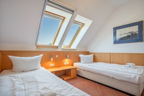 A room with two beds, a small table, and a window. - Ideal for Families & Pets – "Dream Vacation" Apartment with Terrace (Mellenthin)