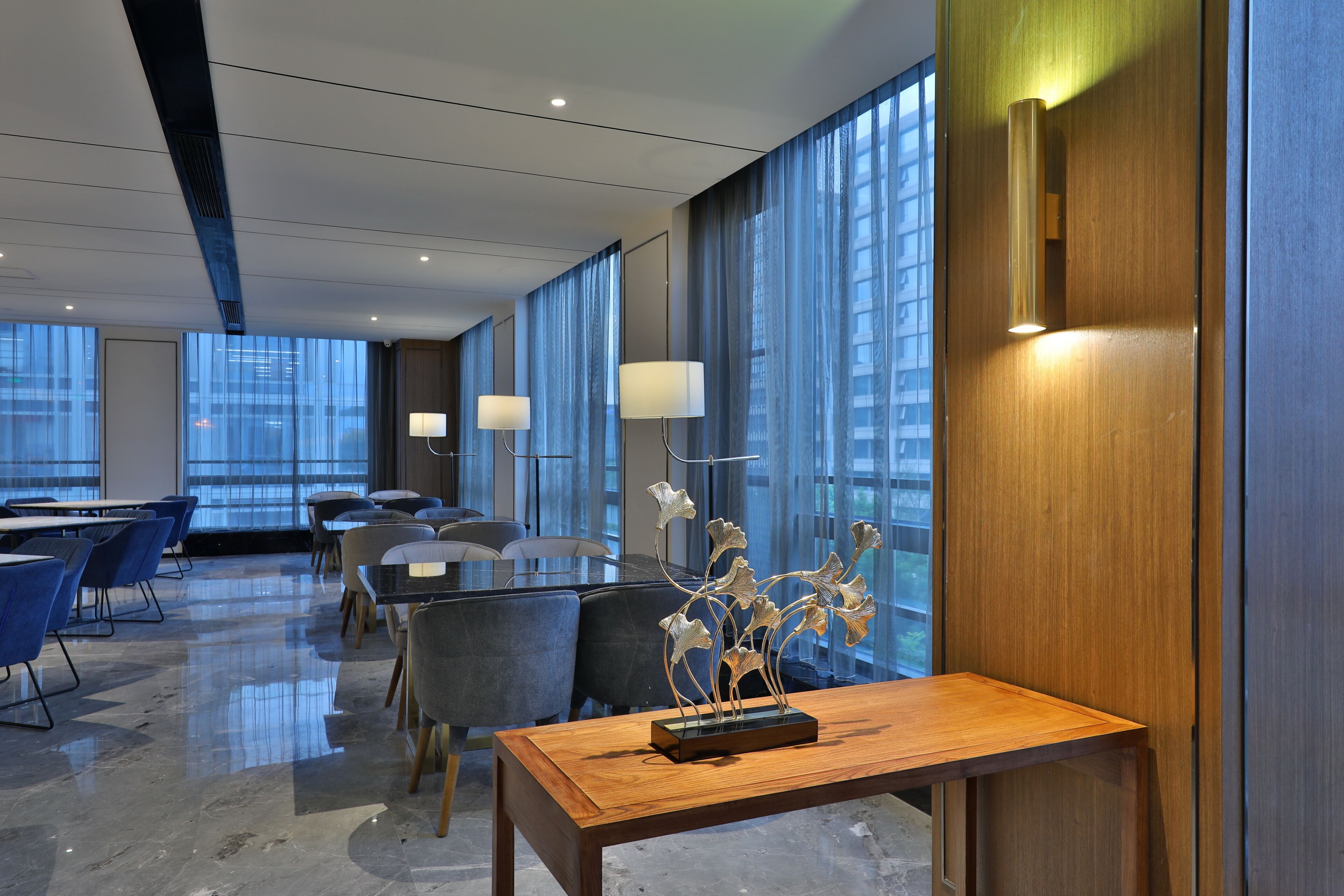 A modern conference room with a long table, chairs, and a decorative metal sculpture centerpiece.