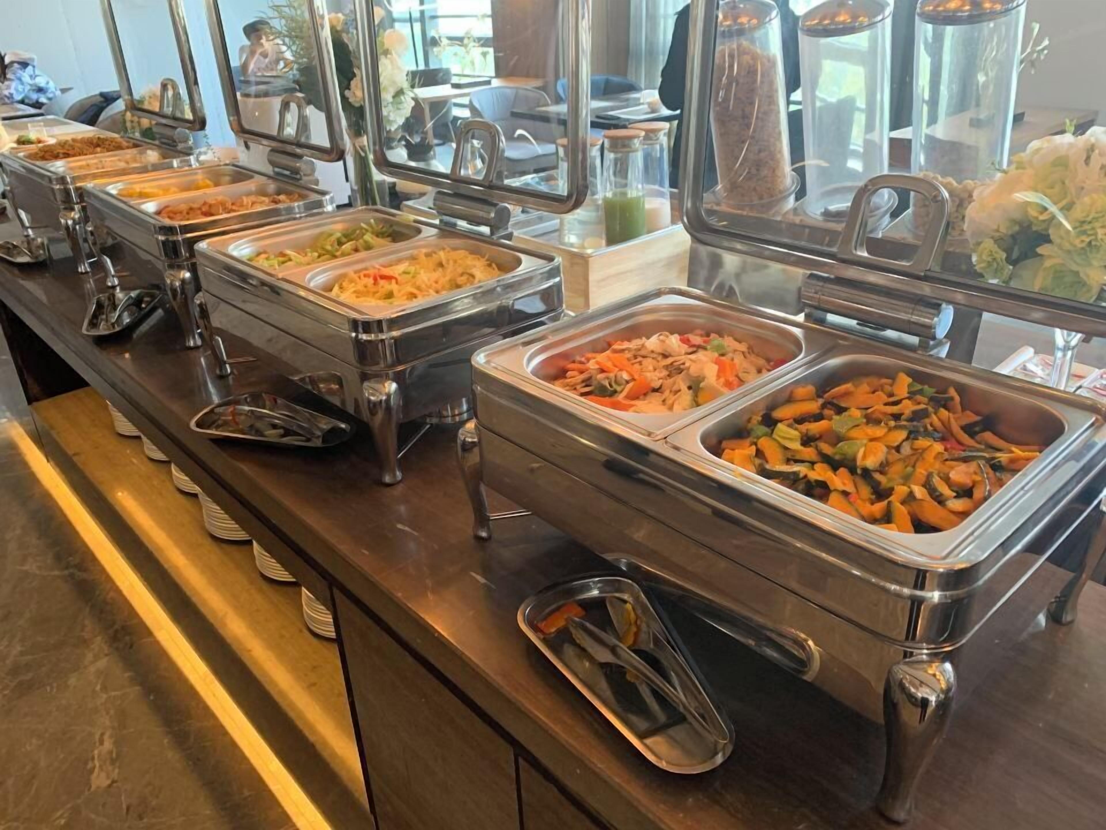 Un bufé con múltiples estaciones de comida, cada una con una variedad de platos.