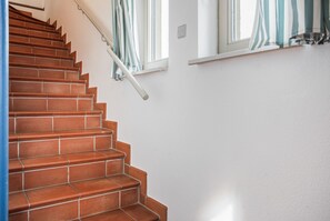 A staircase with terracotta steps and white walls. - Holiday Apartment "Achterwasser View" – Balcony & Nature in Usedom's Hinterland (Mellenthin)